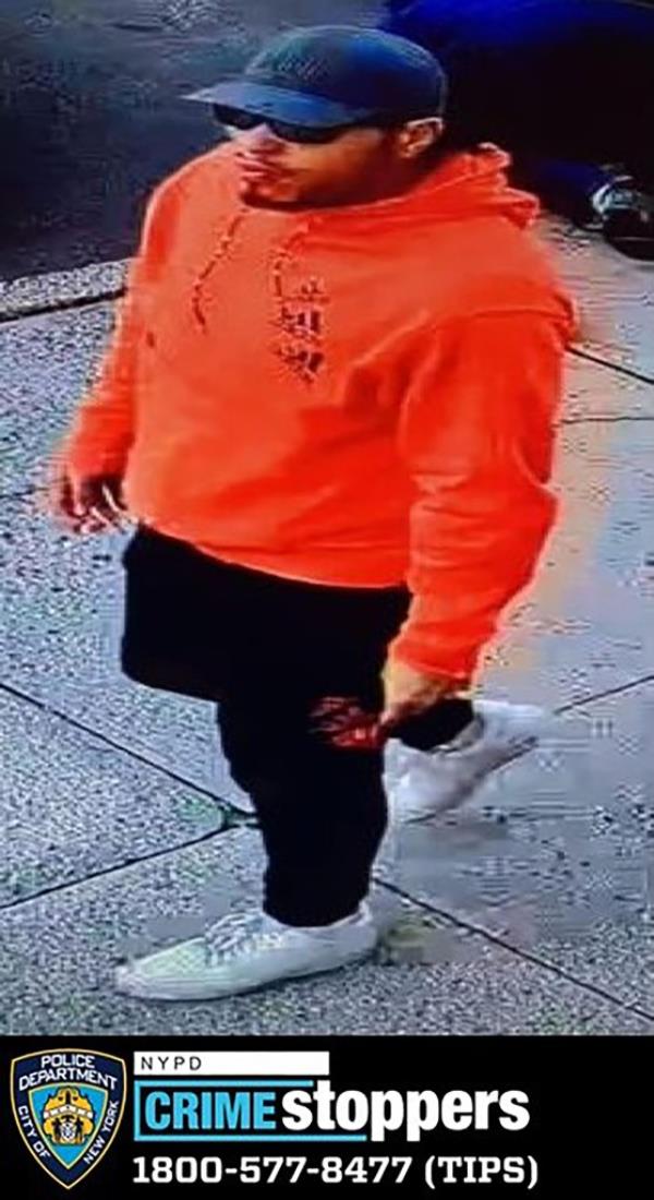 The suspect in the broad-daylight assault on a 65-year-old man, seen wearing sunglasses and an orange hoodie.