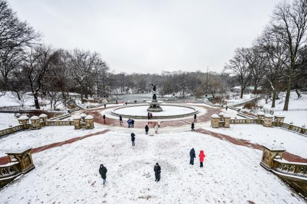 People walk around the Bethesda Fountain as snow blankets New York City — breaking a two year stretch without snow on Jan. 16, 2024. 