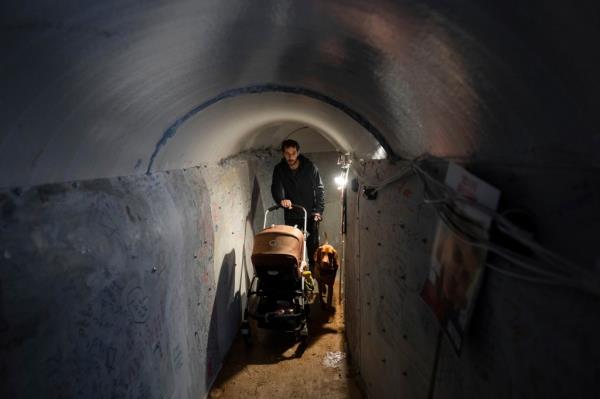 Israelis walk through an installation simulating the tunnels in Gaza wher<em></em>e thee hostages are believed to be held.