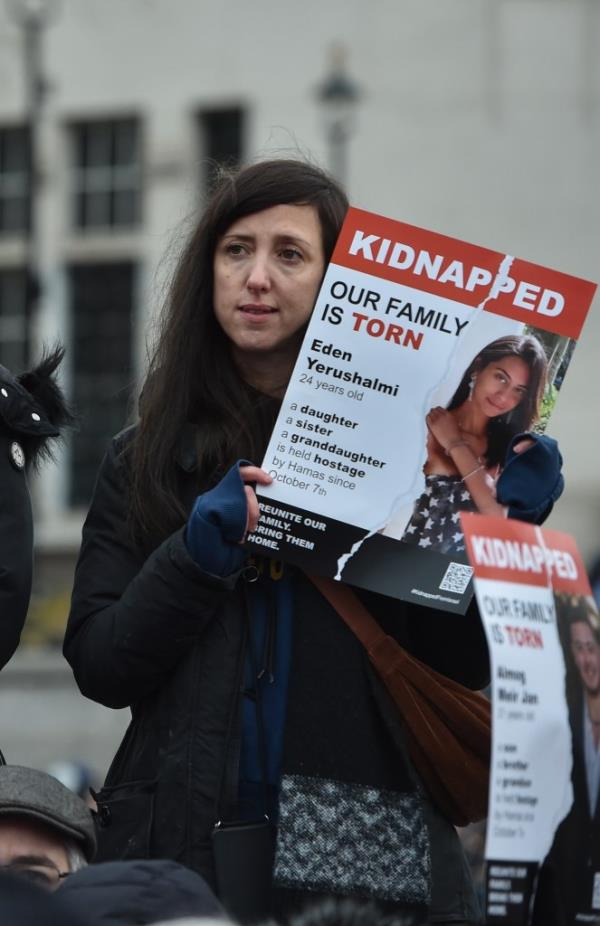 A woman holds a poster of one of the women who has been kidnapped by Hamas.